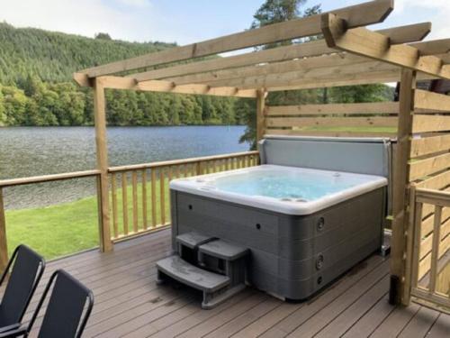 a hot tub on a deck with a pergola at Chalet Invergarry Combi by Interhome in Spean Bridge