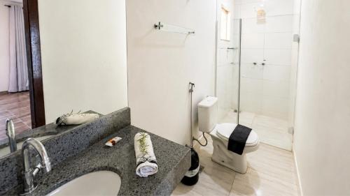 a bathroom with a sink and a toilet at Brisa do Lago Pousada in Capitólio