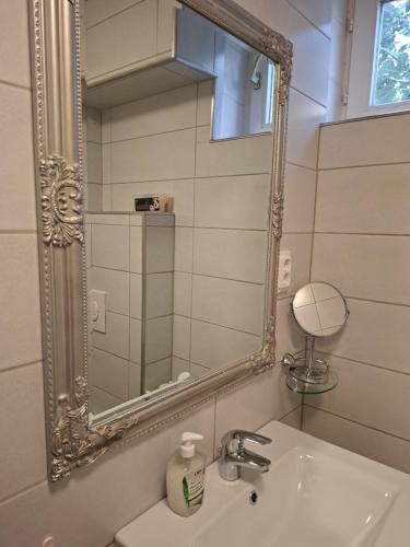 a bathroom with a mirror and a sink at Frix Balaton in Balatonalmádi