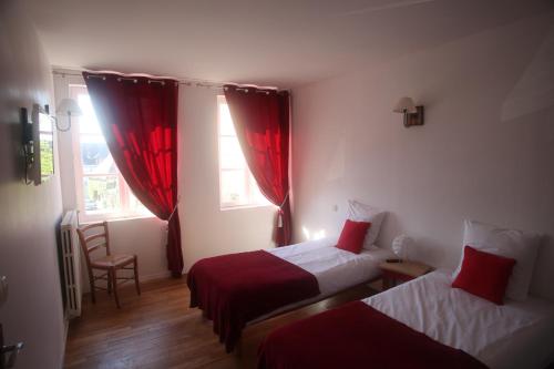 a hotel room with two beds and red curtains at hôtel du centre in Saint-Benoît-du-Sault