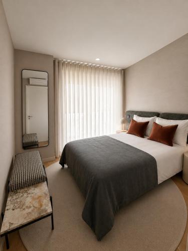a bedroom with a large bed and a large window at Residencial Dom Manuel in Fafe