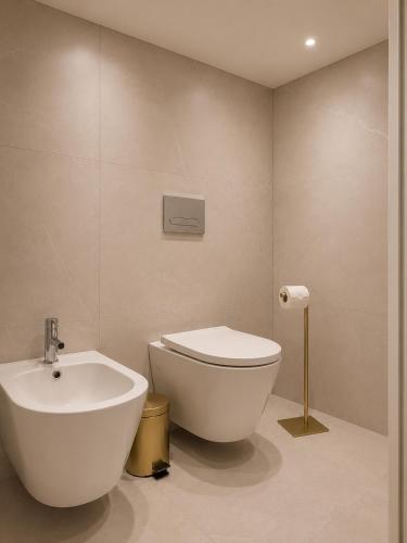 a bathroom with a white toilet and a sink at Residencial Dom Manuel in Fafe
