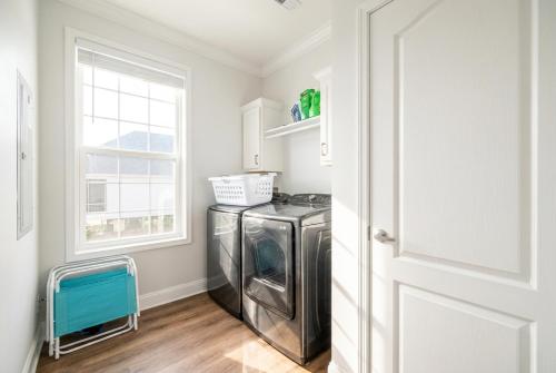 a laundry room with a washer and dryer and a window at Bright Waves Fort Morgan in Gulf Shores