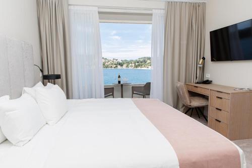 a hotel room with a bed and a desk and a window at Hotel M in Zaton