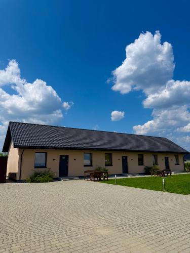 a building with a patio in front of it at Agroturystyka Ostoja Wilków II in Wilków