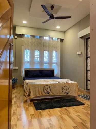 ein Schlafzimmer mit Bett und Deckenventilator in der Unterkunft Aroha Inn in Jorhat