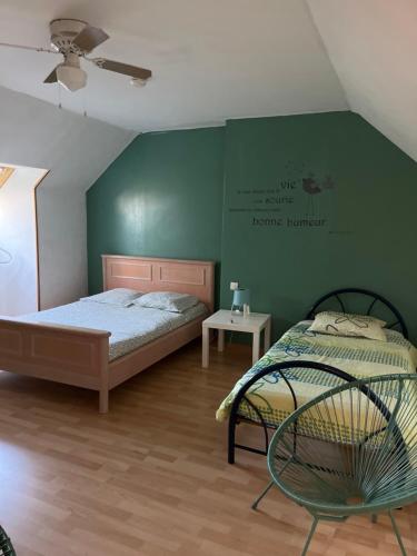 a bedroom with a bed and a green wall at Les Prunus Clermont -Créans 2 personnes in Clermont-Créans