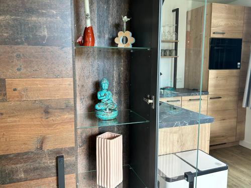 a room with a wooden wall with glass shelves at Vida Bonita in Den Burg