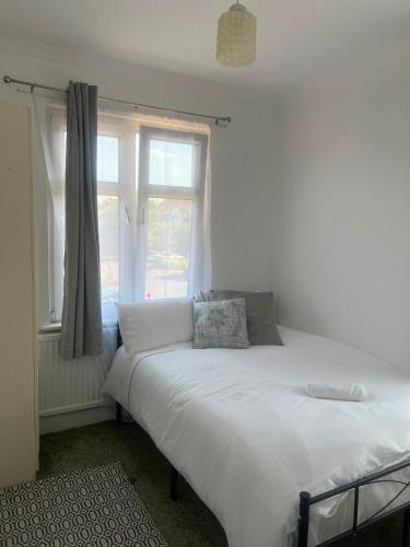 a white bed in a room with a window at Riverside all for you in Kingston upon Thames