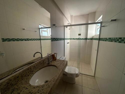 a bathroom with a sink and a toilet at Espigão Palace Hotel in Resende