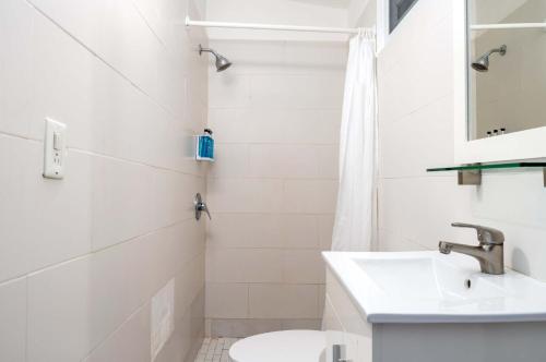 a white bathroom with a sink and a toilet at Elokut in San Juan