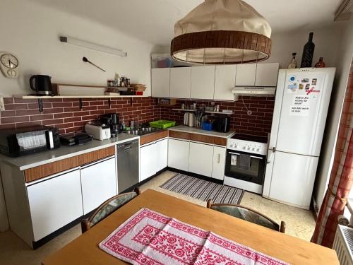 a kitchen with a table and a white refrigerator at Villa Alexander in Bad Hofgastein