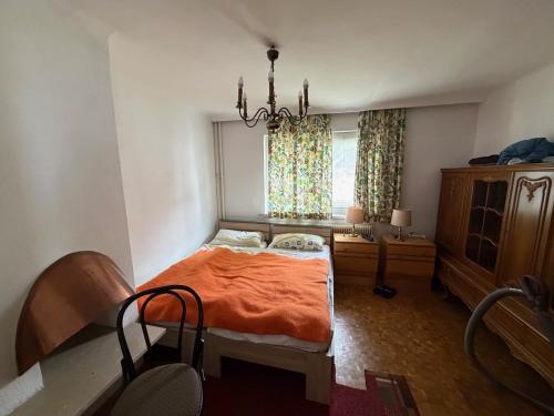 a bedroom with a bed and a table and a window at Villa Alexander in Bad Hofgastein