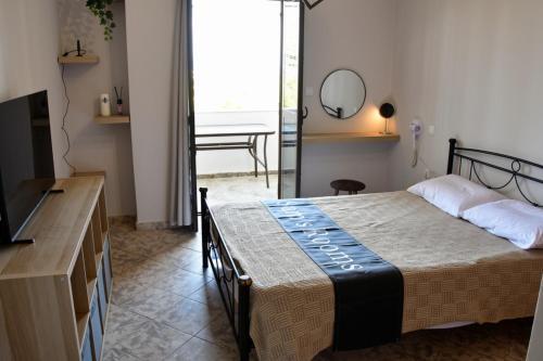 a bedroom with a bed and a table and a mirror at Sam's Rooms in Vathí