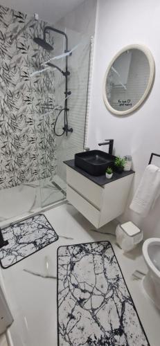 a white bathroom with a sink and a mirror at Casa MIHNEA in Dălghiu