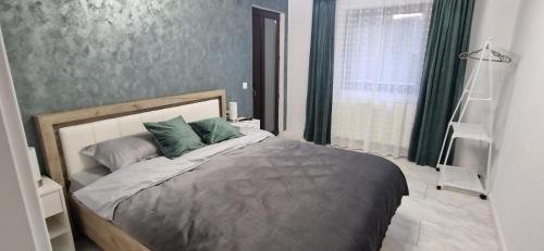 a bedroom with a large bed with green pillows at Casa MIHNEA in Dălghiu