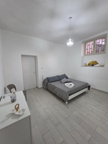 a bedroom with a bed in a white room at Puteoli Stop vacation home in Pozzuoli