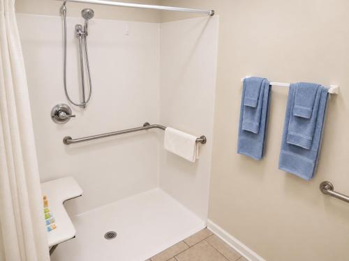 a bathroom with a shower with blue towels at Tumbleweed Inn & Suites in Alexander