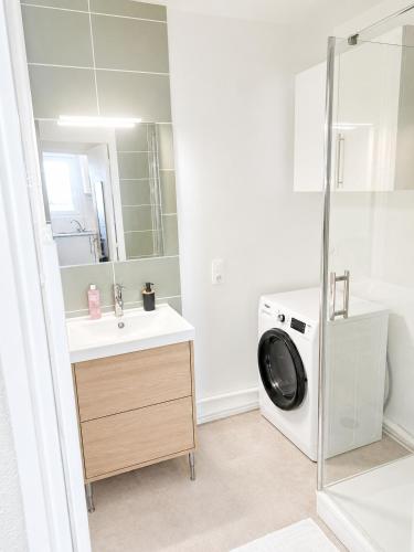 a bathroom with a washing machine and a sink at L'Élégant - 2 Voyageurs in Reims