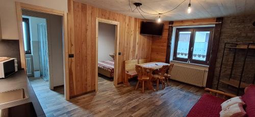 a room with a table and a room with a bedroom at Appartamento Oserot in Bersezio