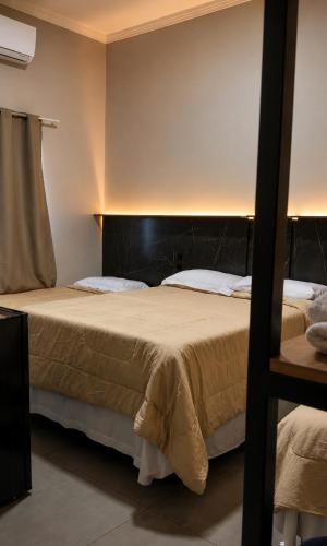 two beds in a hotel room with at Hotel Miranda Maracaju in Maracaju