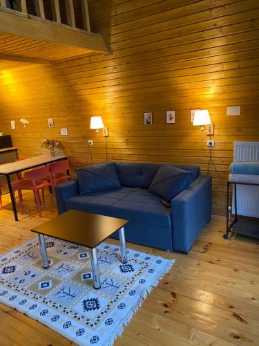 a living room with a blue couch and a table at Sunny Side Cottage in Kazbegi