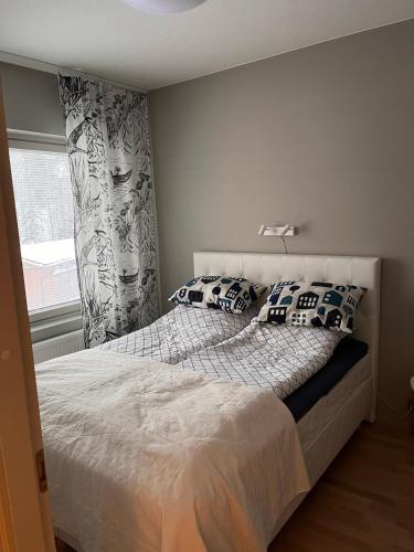 a bedroom with a bed with pillows and a window at Vierumäki Chalets 6 A4904 in Heinola