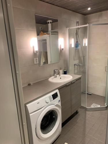 a bathroom with a washing machine and a sink at Vierumäki Chalets 6 A4904 in Heinola