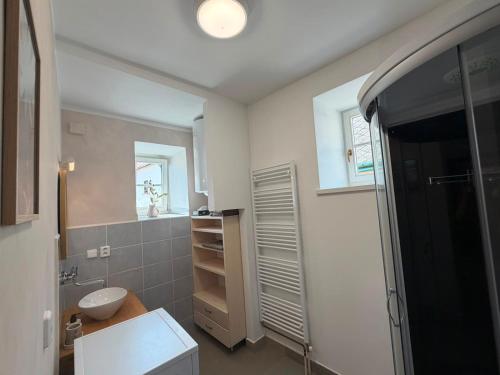 a white bathroom with a sink and a toilet at V srdci Telče - Apartmán in Telč