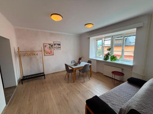 a living room with a table and a bed at V srdci Telče - Apartmán in Telč
