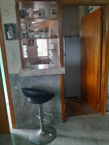 a bar with a stool in a kitchen with a refrigerator at Departamento amplio in Fernando de la Mora