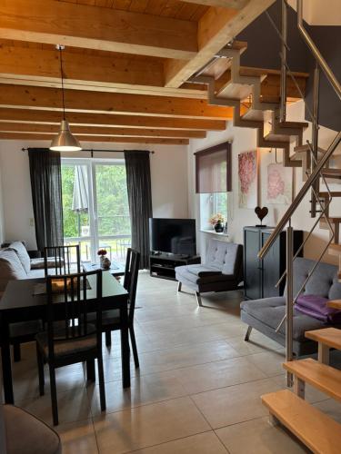 a dining room and living room with a table and chairs at Las,Jezioro,Masaże,SPA in Ostrzyce