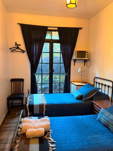 a hotel room with two beds and a window at LA CASITA in Buenos Aires