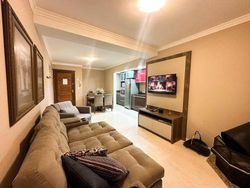 a living room with a couch and a flat screen tv at Canela Dreams - Stay House Temporada in Canela