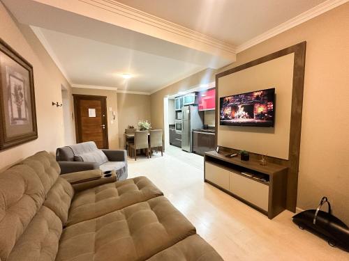 a living room with a couch and a flat screen tv at Canela Dreams - Stay House Temporada in Canela