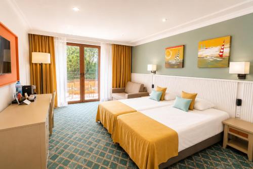 a hotel room with a large bed and a couch at HVD Clubhotel Miramar - 24 Hours Ultra All Inclusive & Free Parking in Obzor
