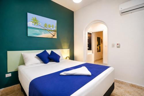 a bedroom with a blue and white bed with blue pillows at Casa roof in Las Terrenas
