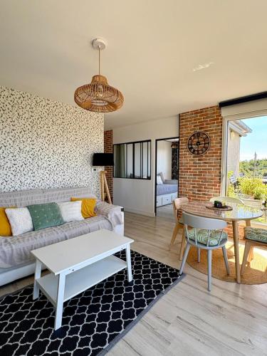 a living room with a couch and a table at ROOF TOP 50m2 VUE MER !! à 2 mn à pied de la PLAGE et de la THALASSOTHERAPIE ! in Concarneau
