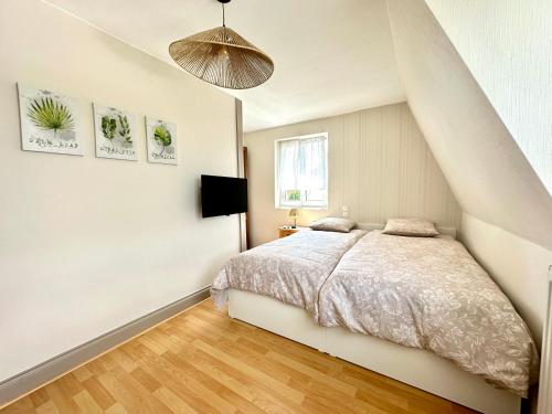a bedroom with a bed and a pendant light at La Parenthèse - Maison avec piscine privée in Wissembourg