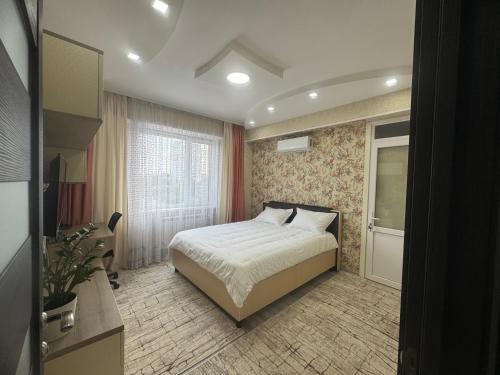 ein Schlafzimmer mit einem Bett und einem Fenster in der Unterkunft Flora in Chişinău