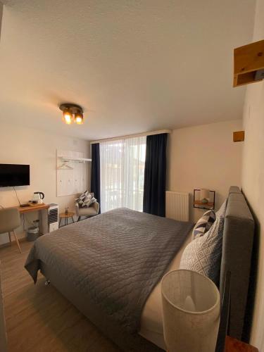 a bedroom with a bed and a desk and a window at Altstadthotel Marktheidenfeld in Marktheidenfeld