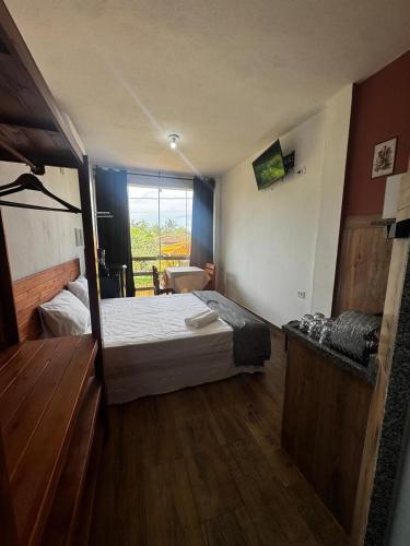 a small bedroom with a bed and a window at Recanto Praia do Sargi in Uruçuca