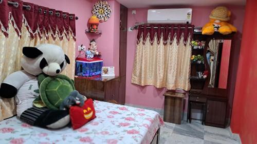 a room with a stuffed panda bear sitting on a bed at Swapna-Nir in Howrah