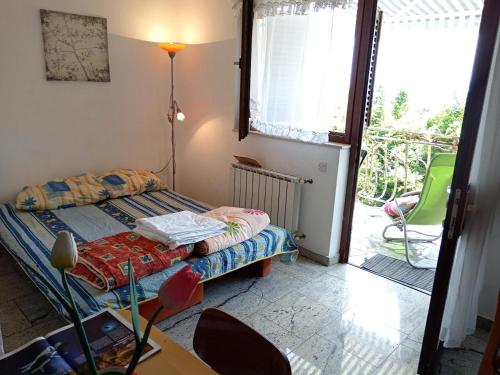 a small bedroom with a bed and a balcony at Kuća u zelenilu in Poljane