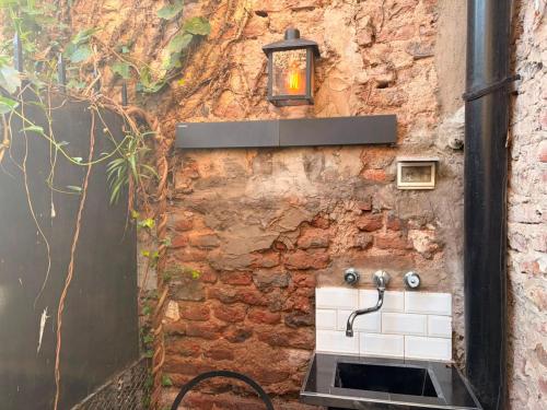 a stone wall with a sink and a light at LA CASITA in Buenos Aires