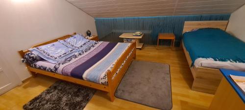 a small bedroom with two beds and a table at Les Nids de Mesanges Chambre d'hôtes in Selonnet