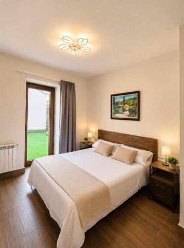 a bedroom with a large white bed and a window at Villa Rural in Cabezuela