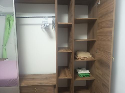 a walk in closet with wooden shelves and a door at Studio en rez-de-chaussée in Hammamet