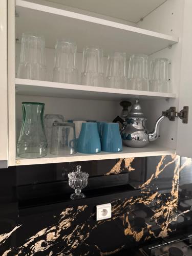 a shelf with many glass vases on it at appart plage in M'diq