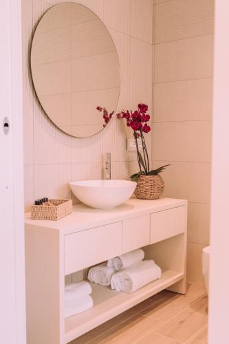 a bathroom with a sink and a mirror at Lentischi Hotel - Adults Only in Villasimius